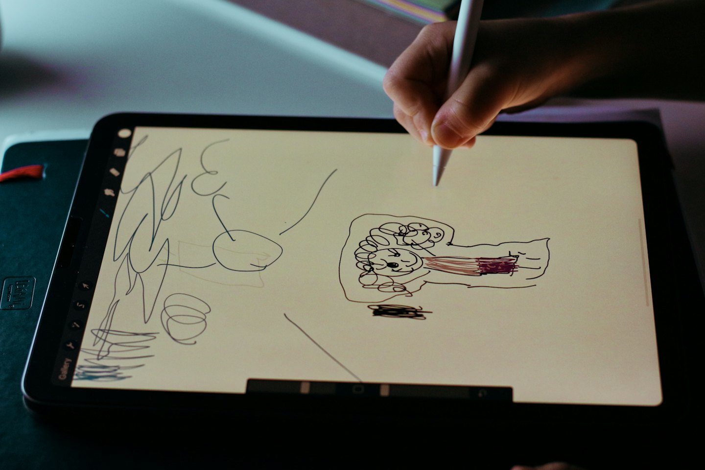 Hand drawing a smiling face on a digital tablet with a stylus.