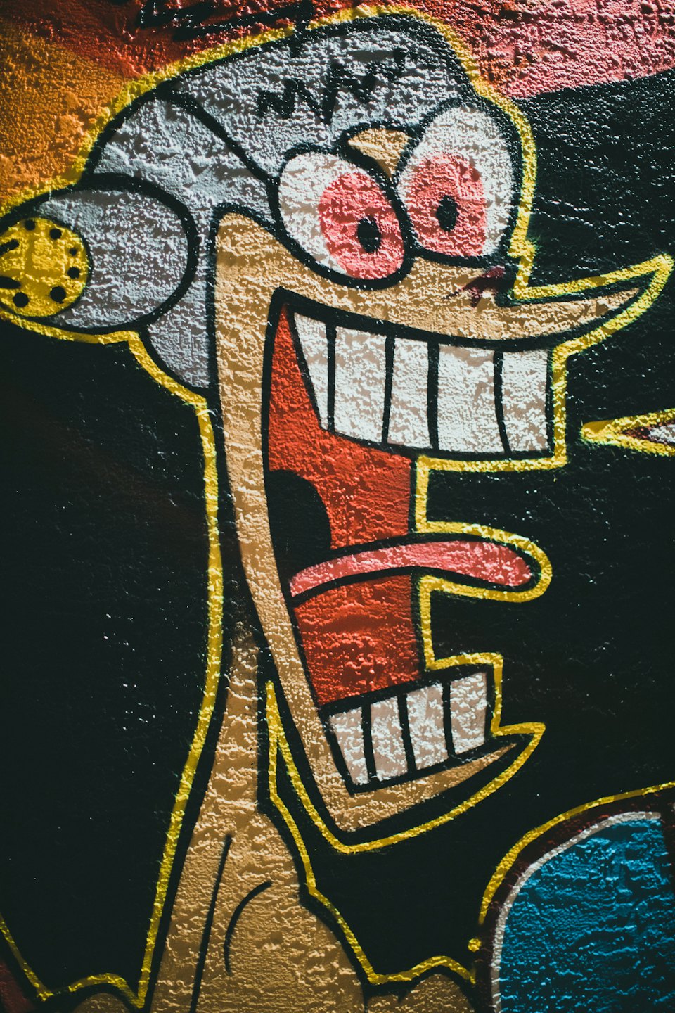 Street art of a cartoon character wearing a branded cap.