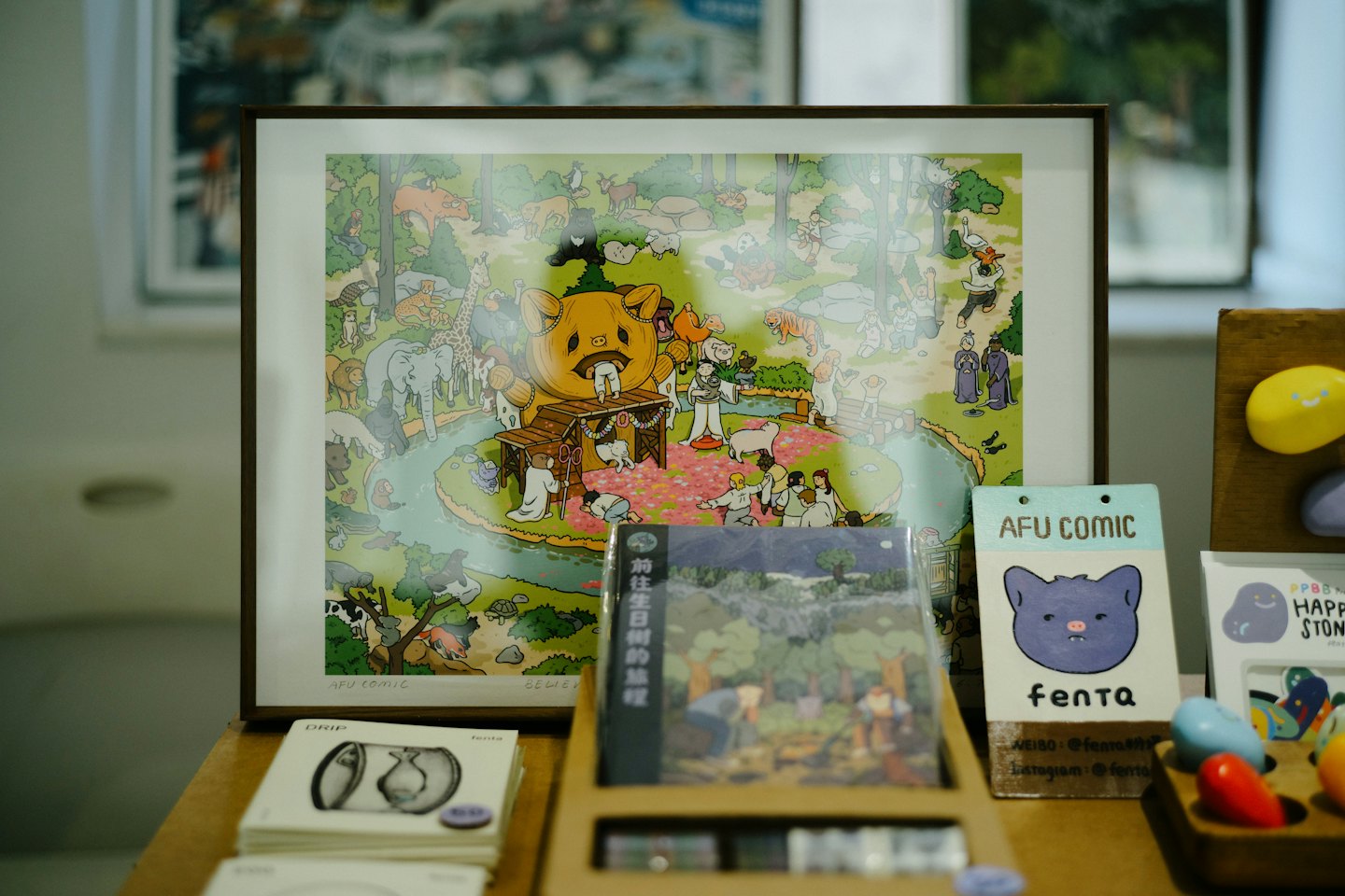 A framed cartoon illustration of a golden creature sits on a table.